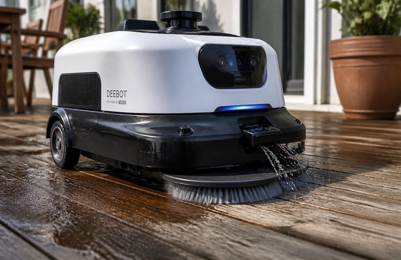 Close-up of an autonomous deck scrubbing robot with a rotating brush head and water spray cleaning timber decking. Image by www.CleaningRobots.Online.