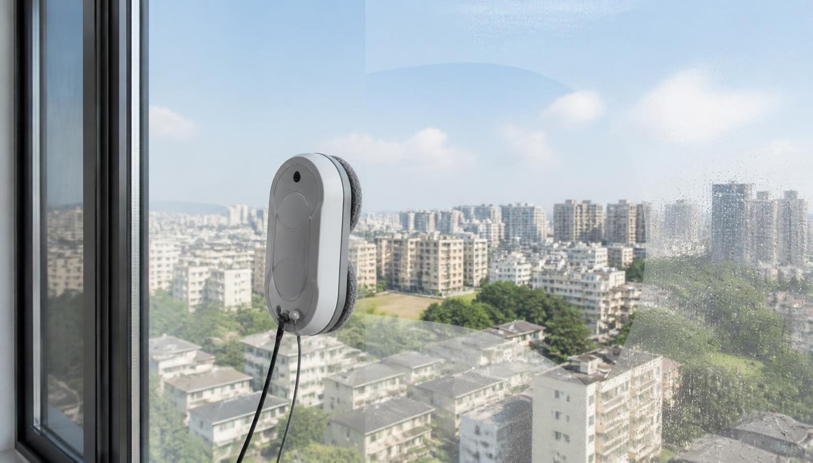 A robot window cleaner attached to a large glass window on a high-rise building. Image by www.CleaningRobots.Online.
